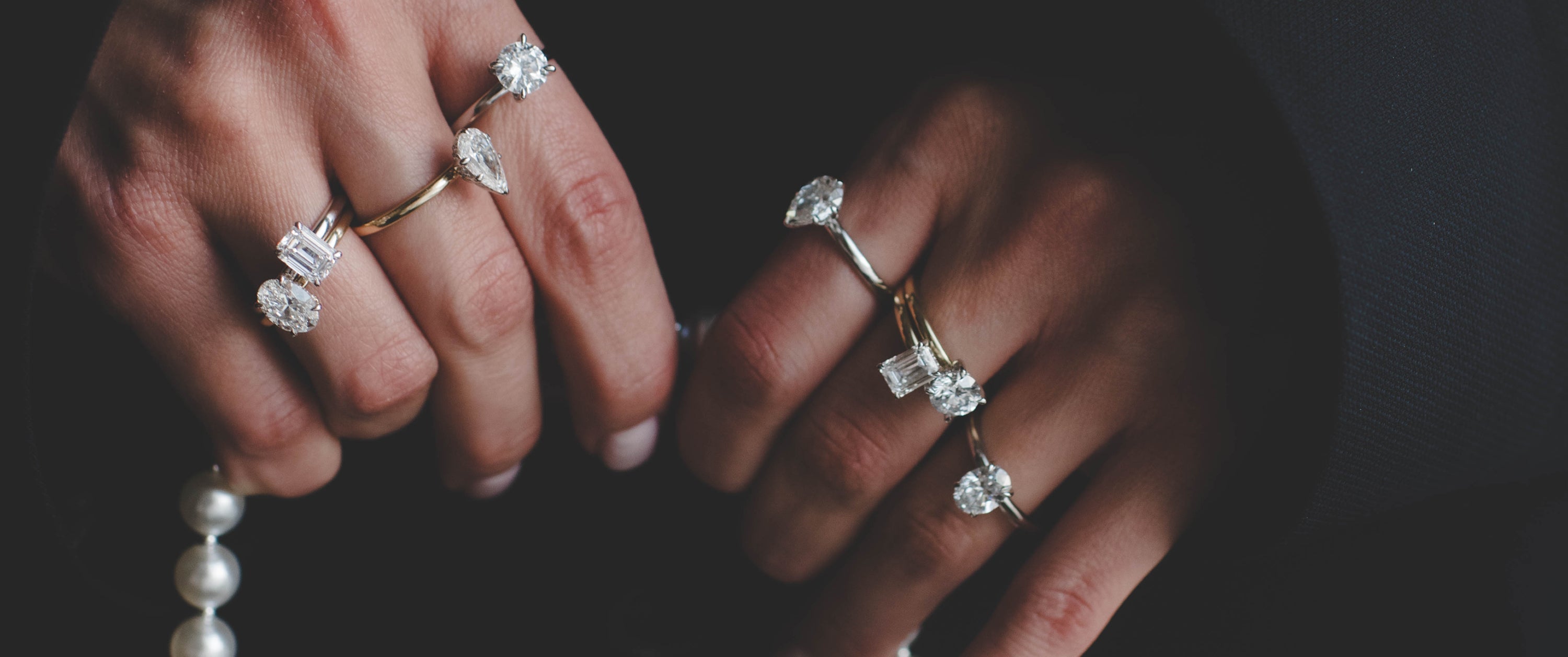 Woman holding a bad with stacked diamond engagement rings