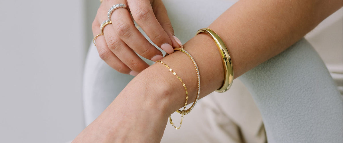 Woman With Stacked Tennis Bracelets and Gold Bangle