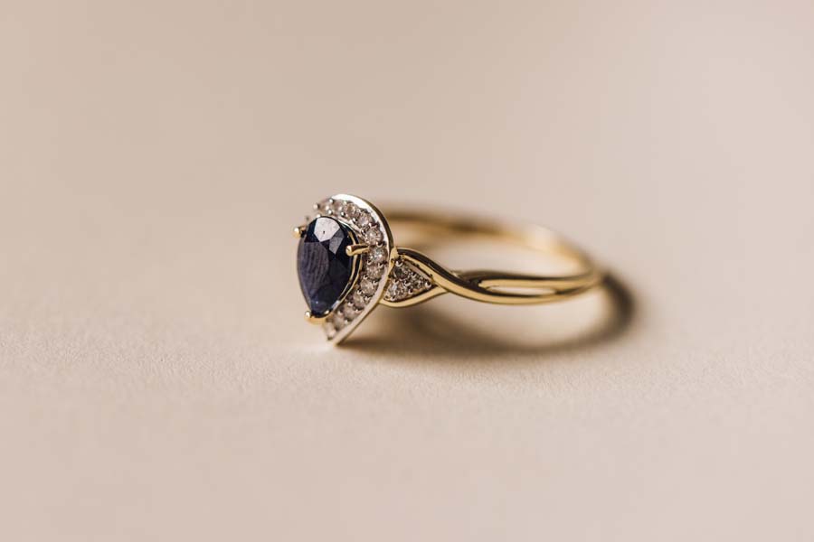 Halo Ring with .17 Carat TW of Diamonds and 7x5MM Pear Shape Blue Sapphire in 10kt Yellow Gold