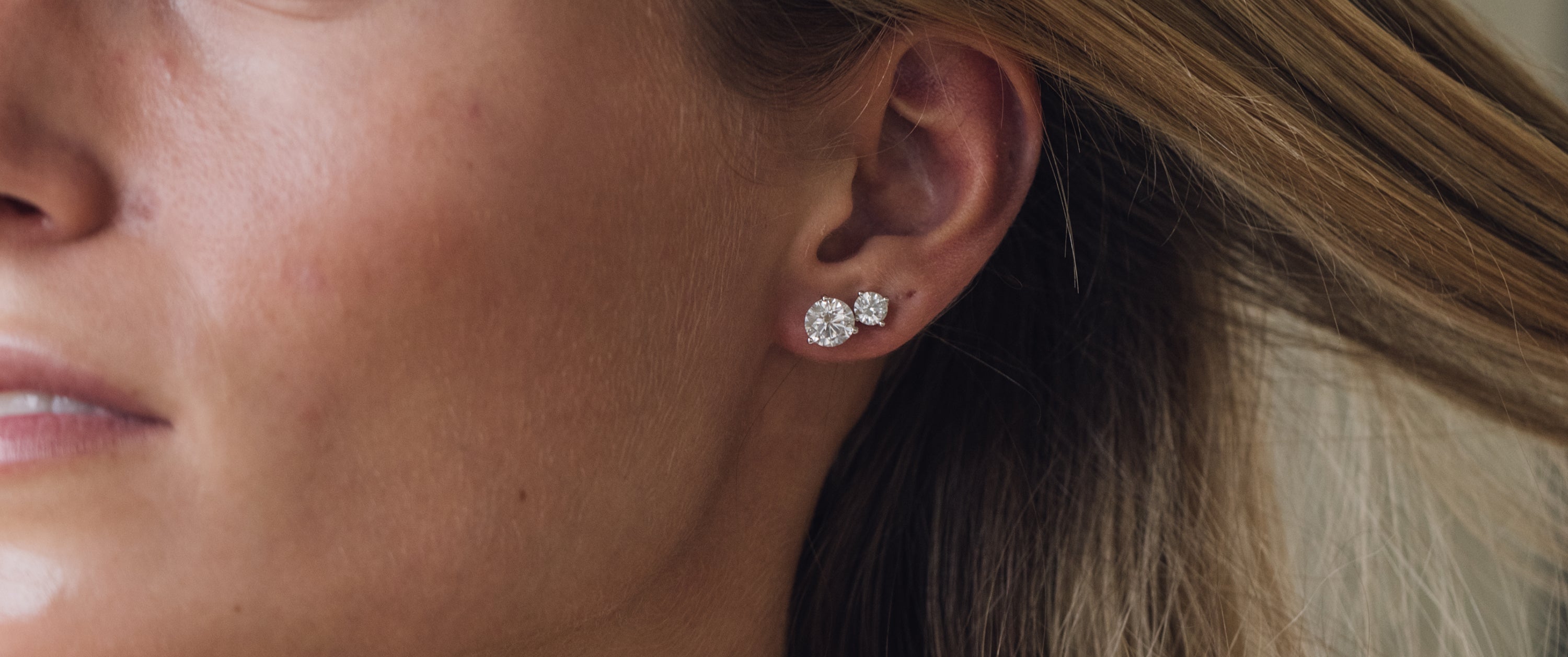 Woman wearing two diamond stud earrings