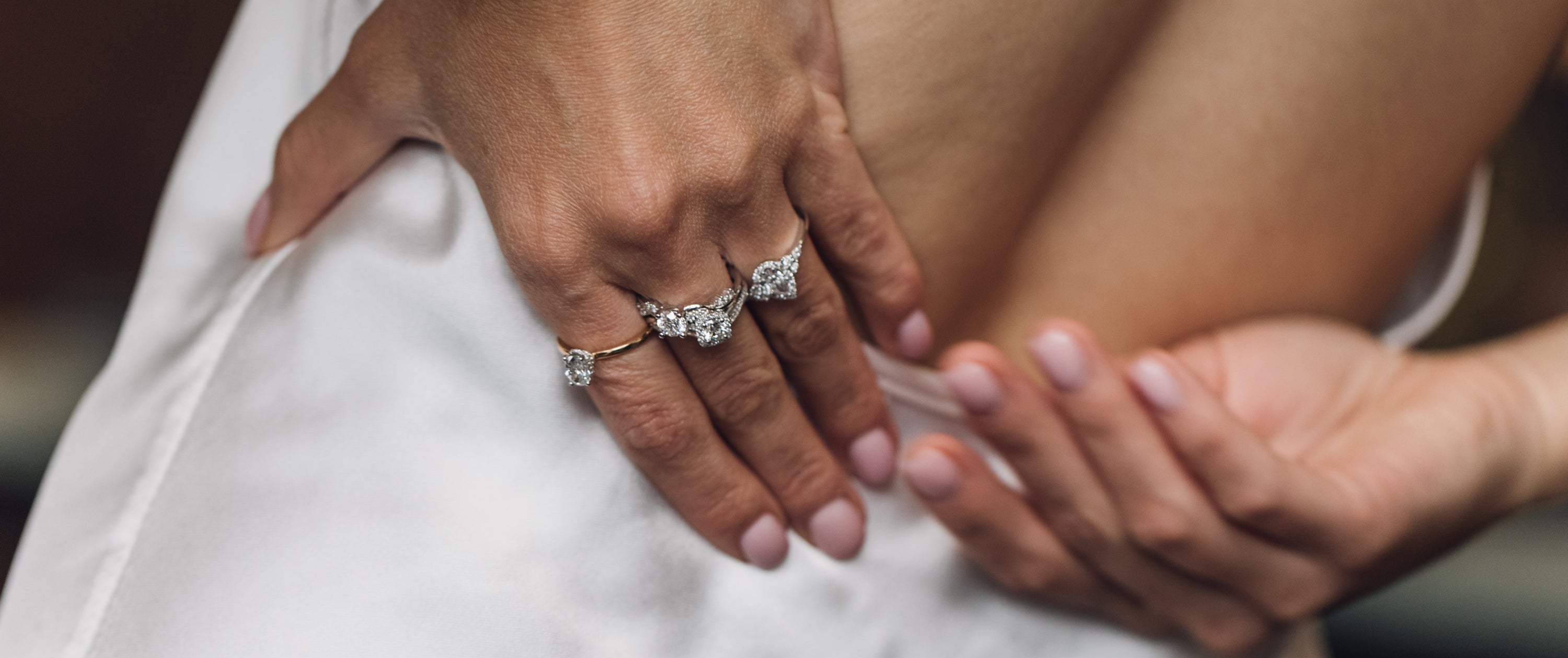 Woman photo with hand on her back and stacked natural diamond engagement rings.