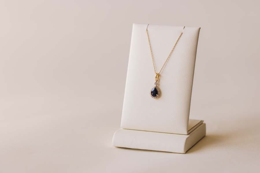 Halo Pendant with .13 Carat TW of Diamonds and 7x5MM Pear Shape Blue Sapphire in 10kt Yellow Gold with Chain